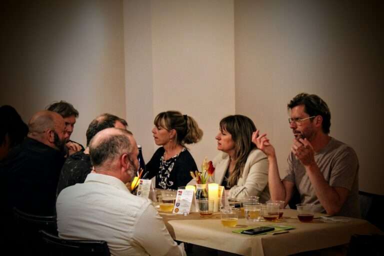 Photo of people eating together at Paired Provisions, an event which brings together some of the region's finest specialty food and beverage producers for a guided tasting experience, surrounded by contemporary art in the Jane Altes Gallery, in Troy, NY.