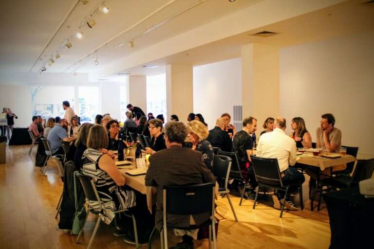 People eating in the art gallery for the wine and dine event, Paired Provisions, at The Arts Center of The Capital Region